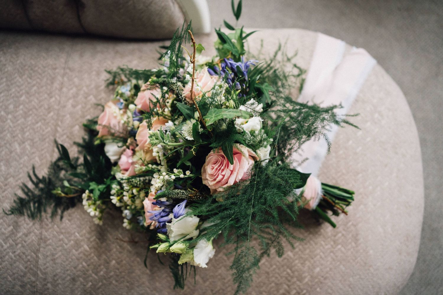 A series of elegant floral arrangements with roses and greenery displayed on a light gray textured surface.