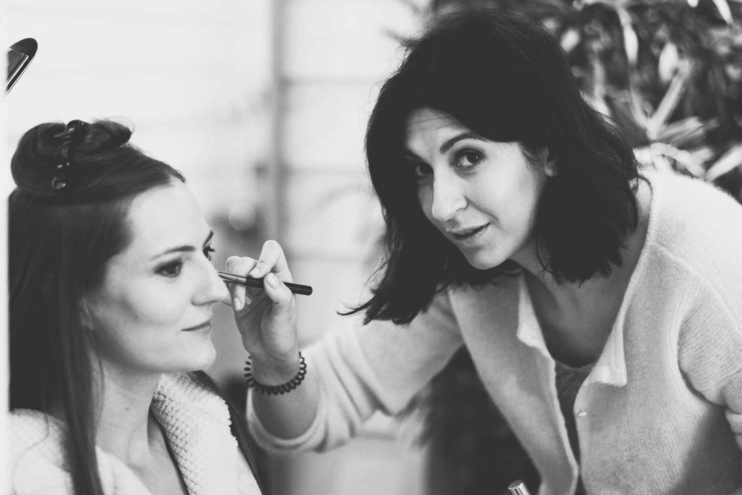 A behind the scenes moment of makeup application being done in black and white.