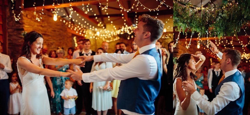 Wedding reception dance floor lit by romantic string lights in rustic wooden venue.