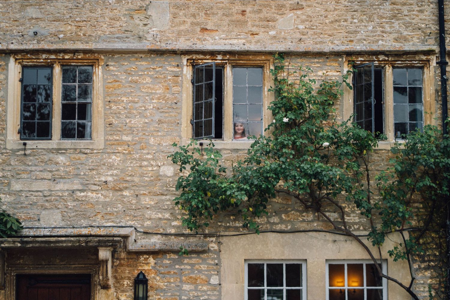 Historic stone building facade with traditional windows and climbing vines along the exterior walls.