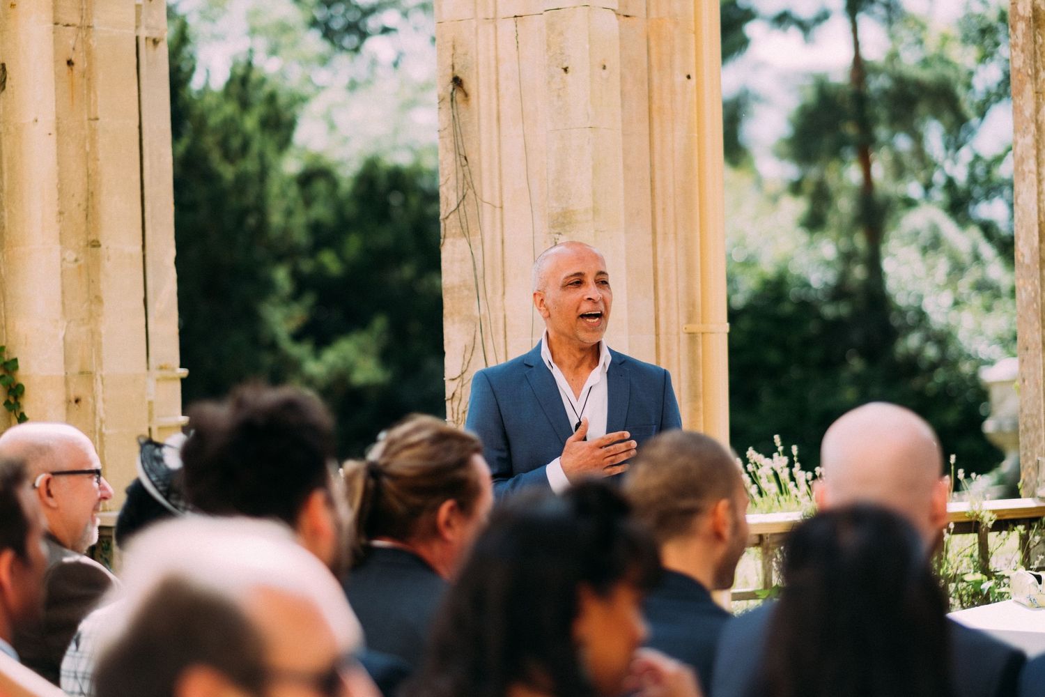 A guest speaker shares an emotional moment during an outdoor wedding reception.