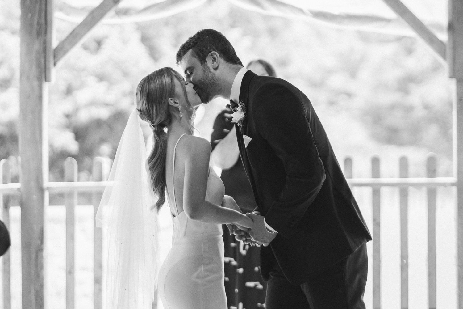 A couple shares an intimate dance moment together on a covered porch in black and white.