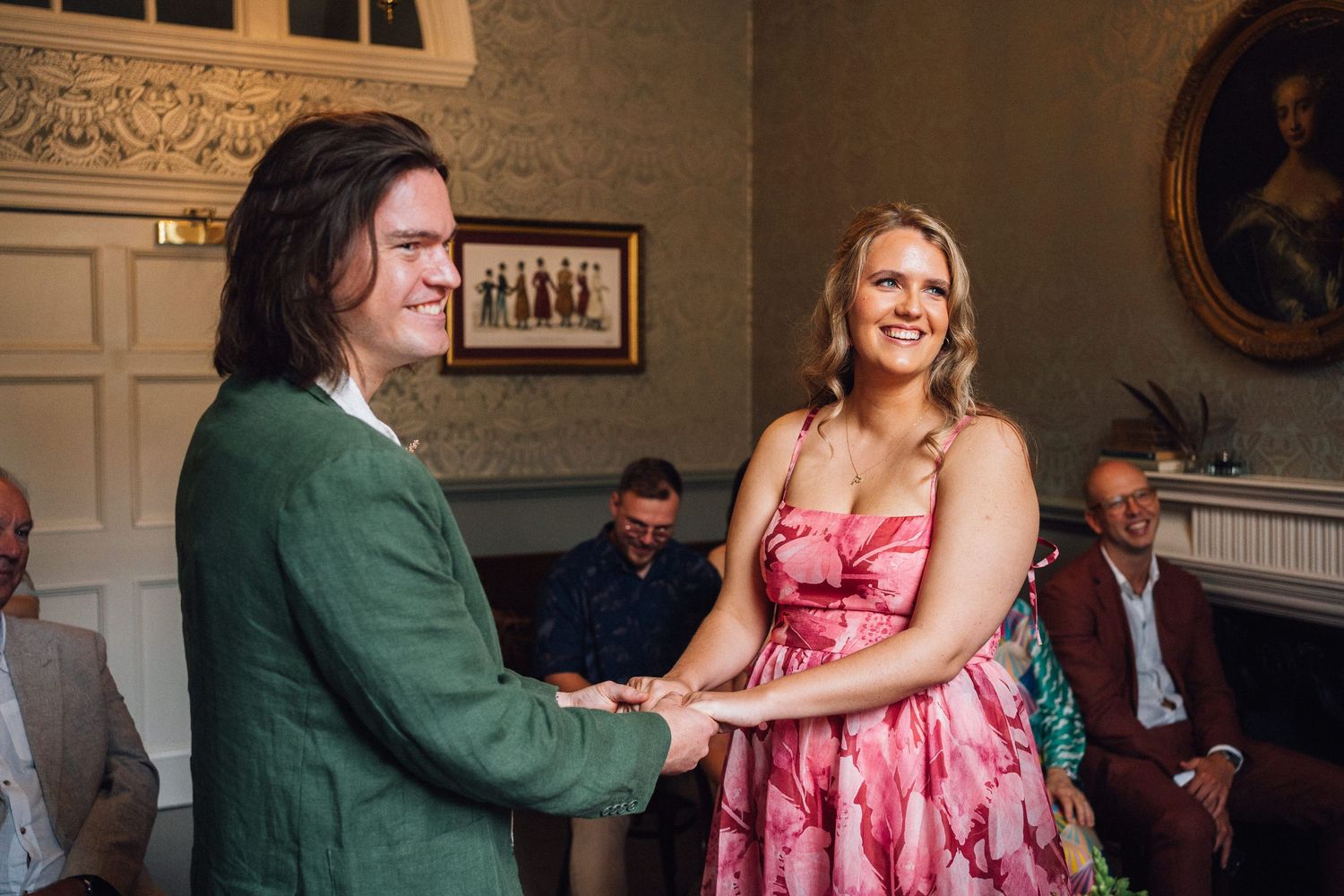Two people dancing and laughing together in a formal setting with classic interior design.