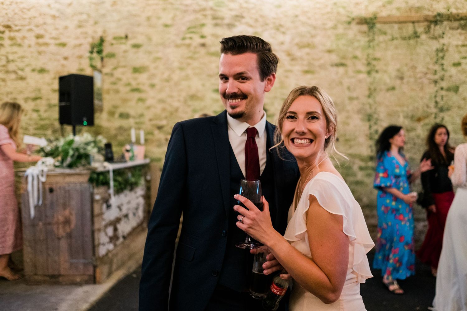 Wedding celebration in a rustic stone barn with natural lighting and vintage decor.