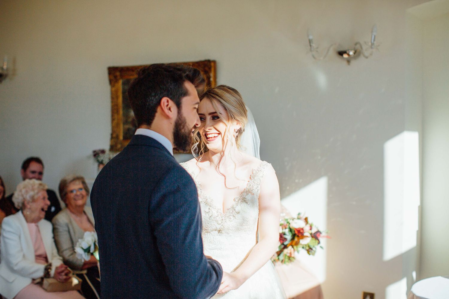 Romantic wedding ceremony moment unfolds in a bright, minimalist indoor venue.