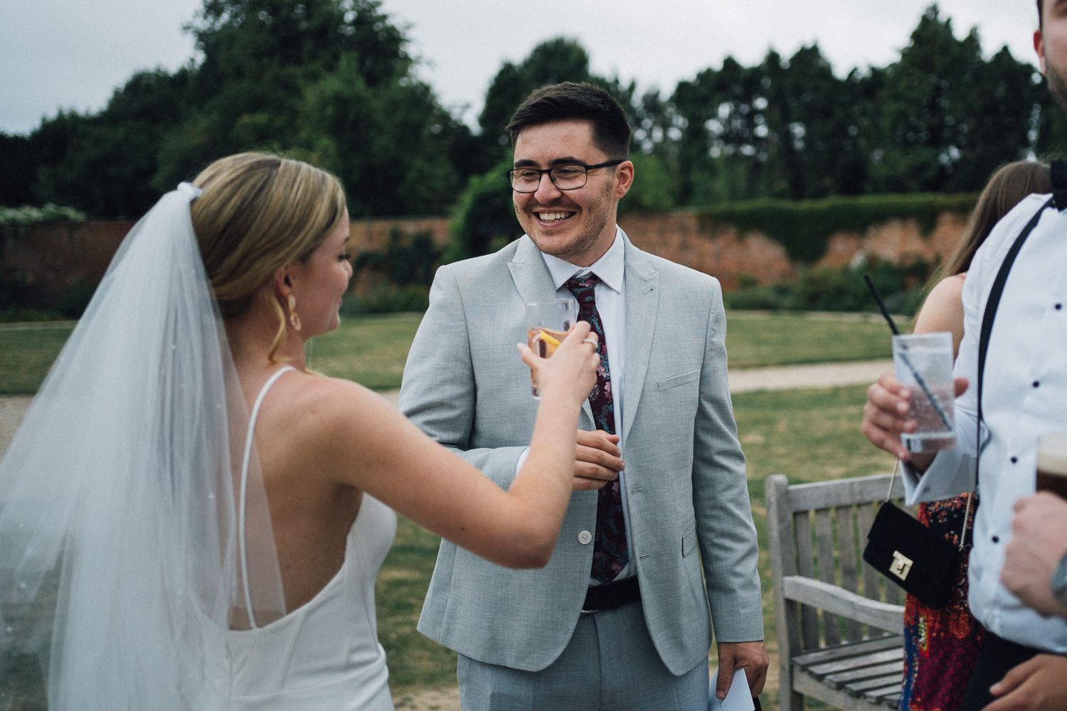 A bride and groom share a candid moment during their outdoor wedding celebration.