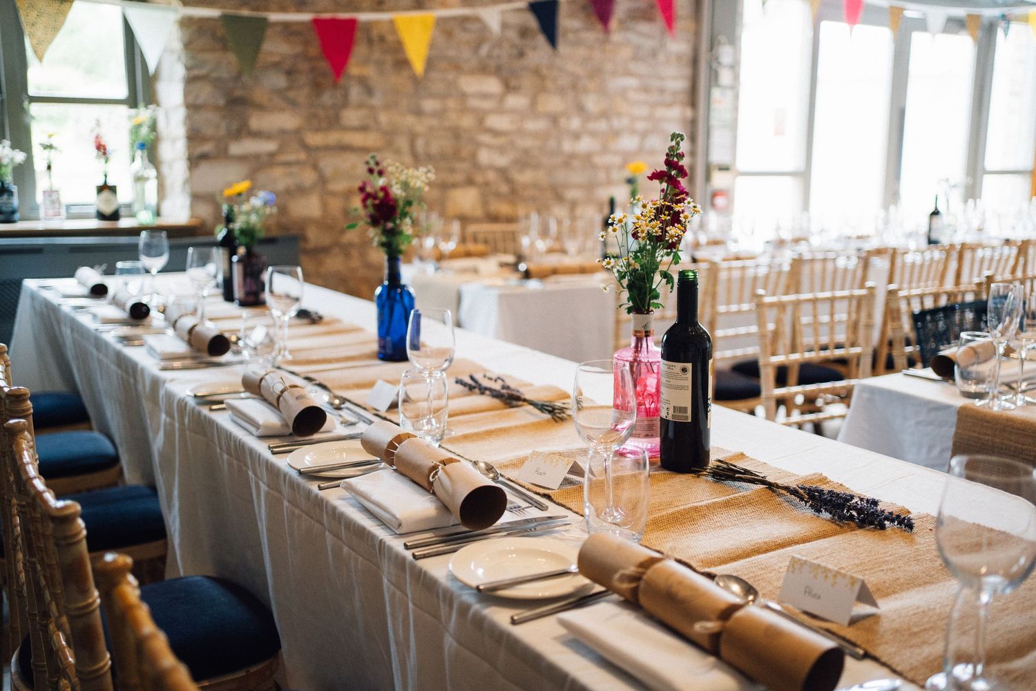 Wedding reception table settings with kraft paper details and simple floral centerpieces.