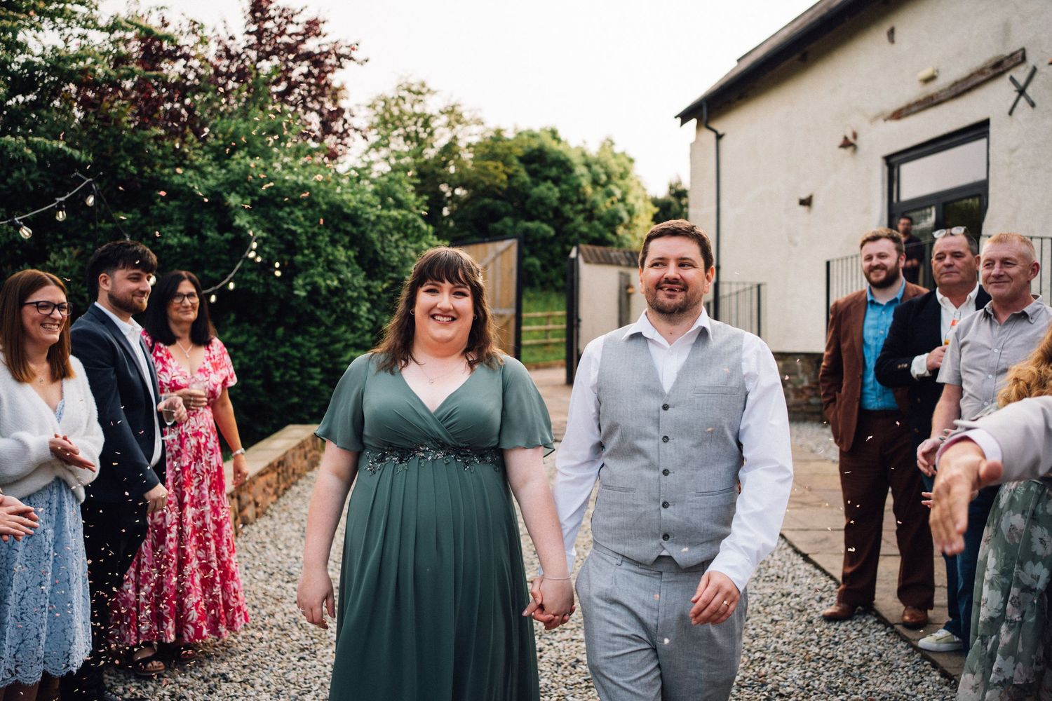 Wedding guests gathered outdoors in casual attire at a rustic venue during a summer celebration.