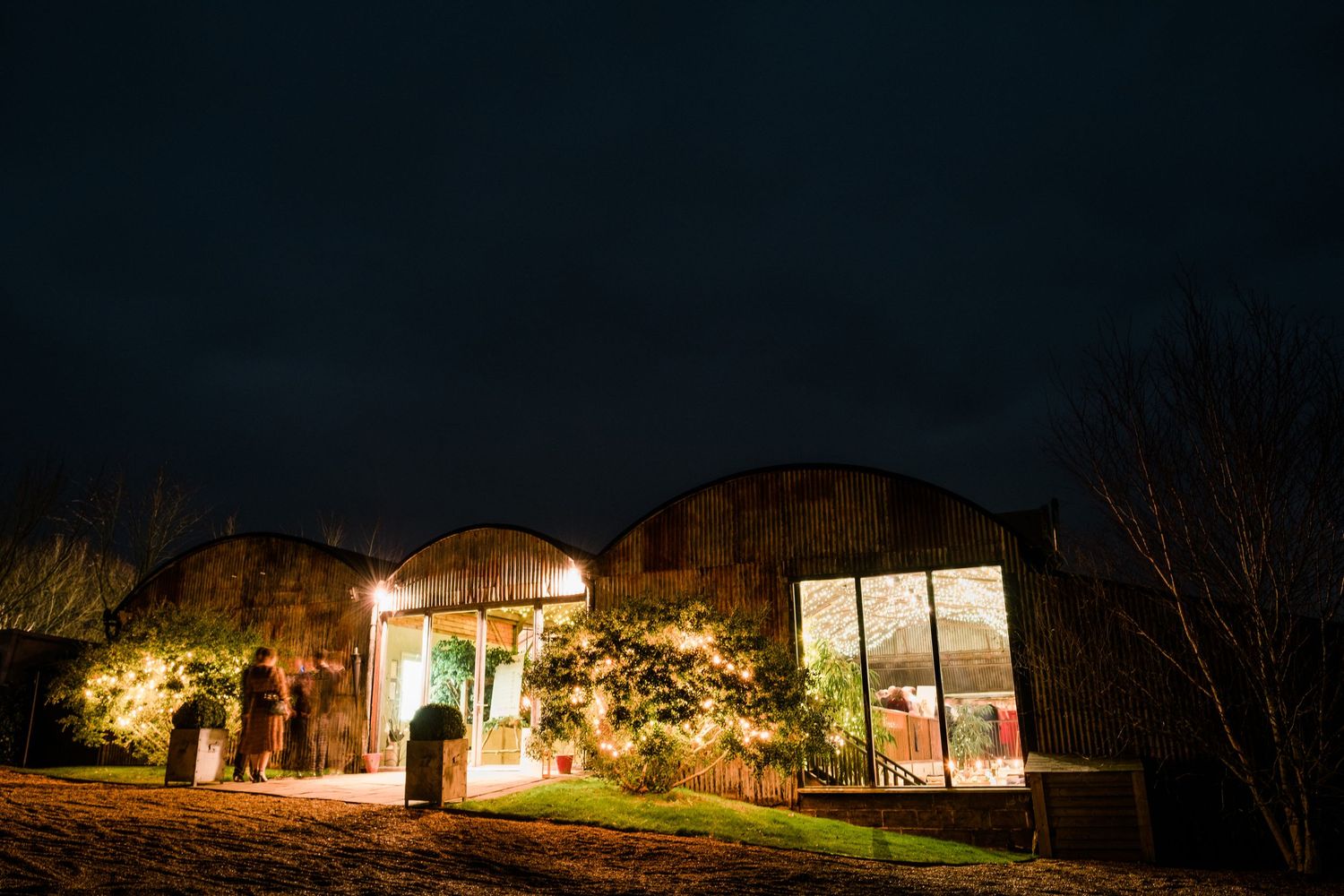 Nighttime exterior view of wedding venue buildings lit up against dark sky.