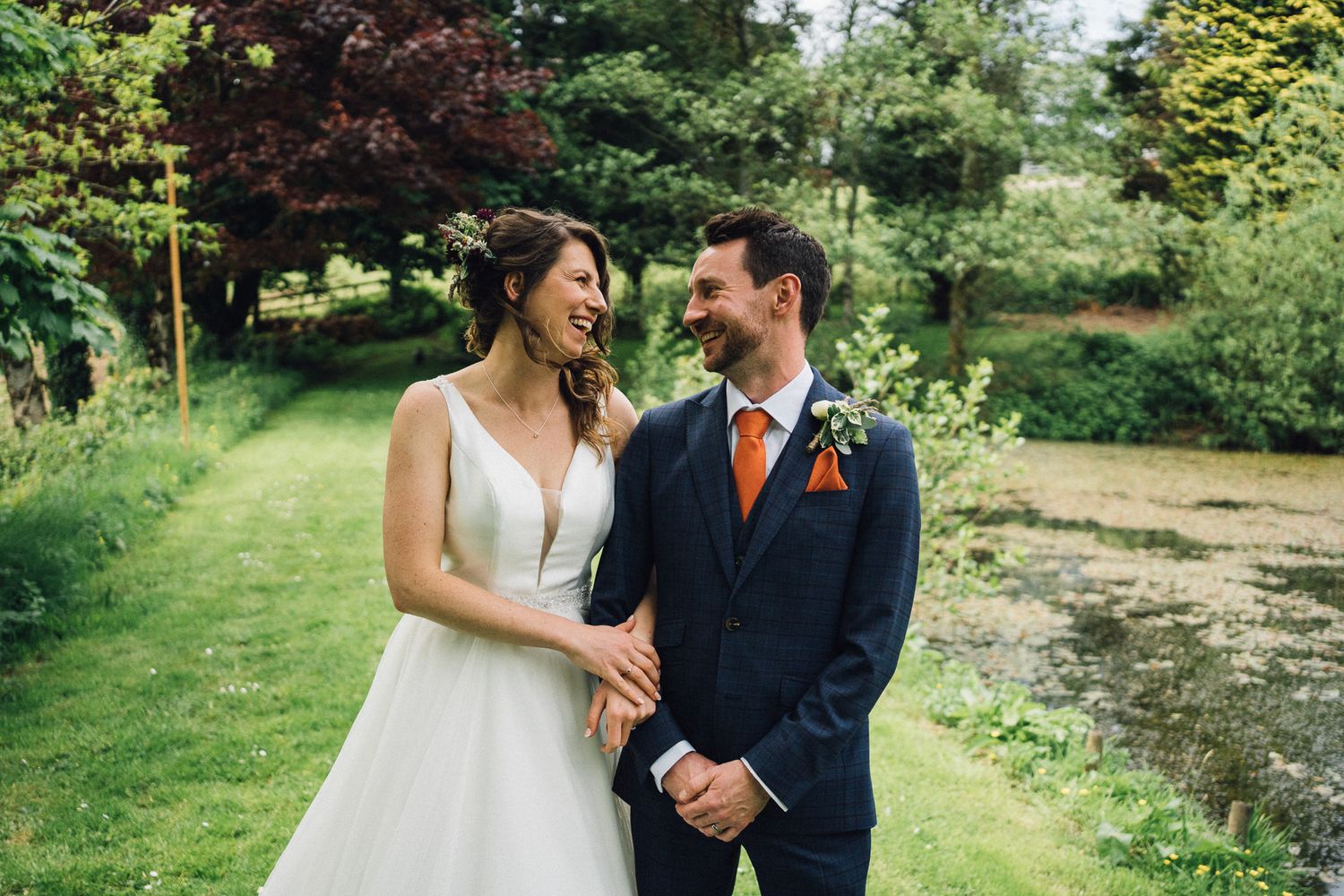 A couple strolls through a beautiful garden landscape on their wedding day.
