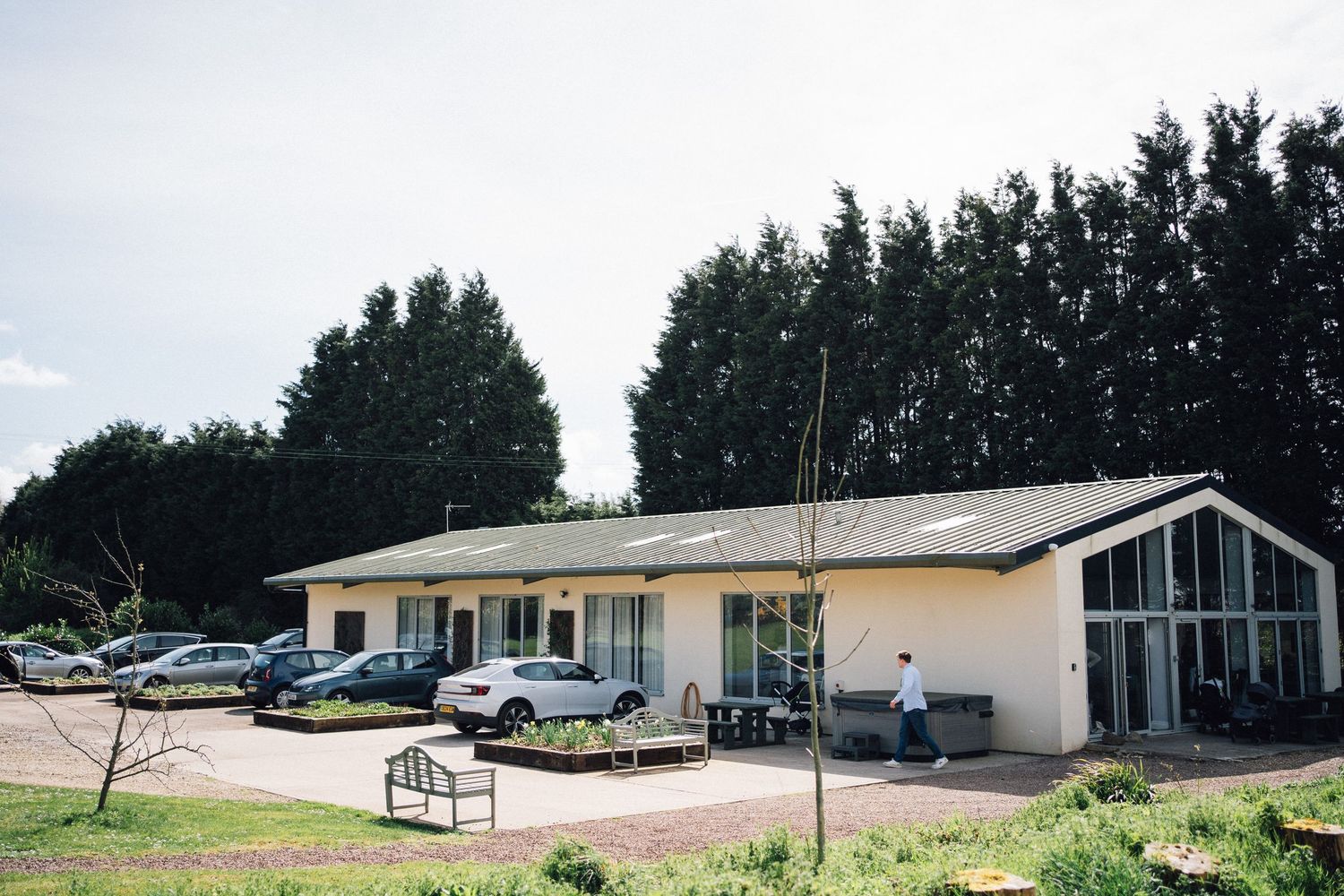 A series of commercial buildings and parking lots surrounded by trees in a rural business park setting.