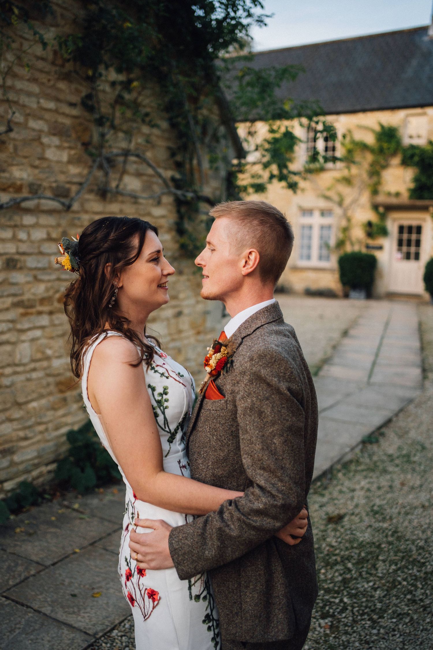 A couple shares intimate moments in a sequence of romantic photos against a stone wall backdrop at a historic venue.