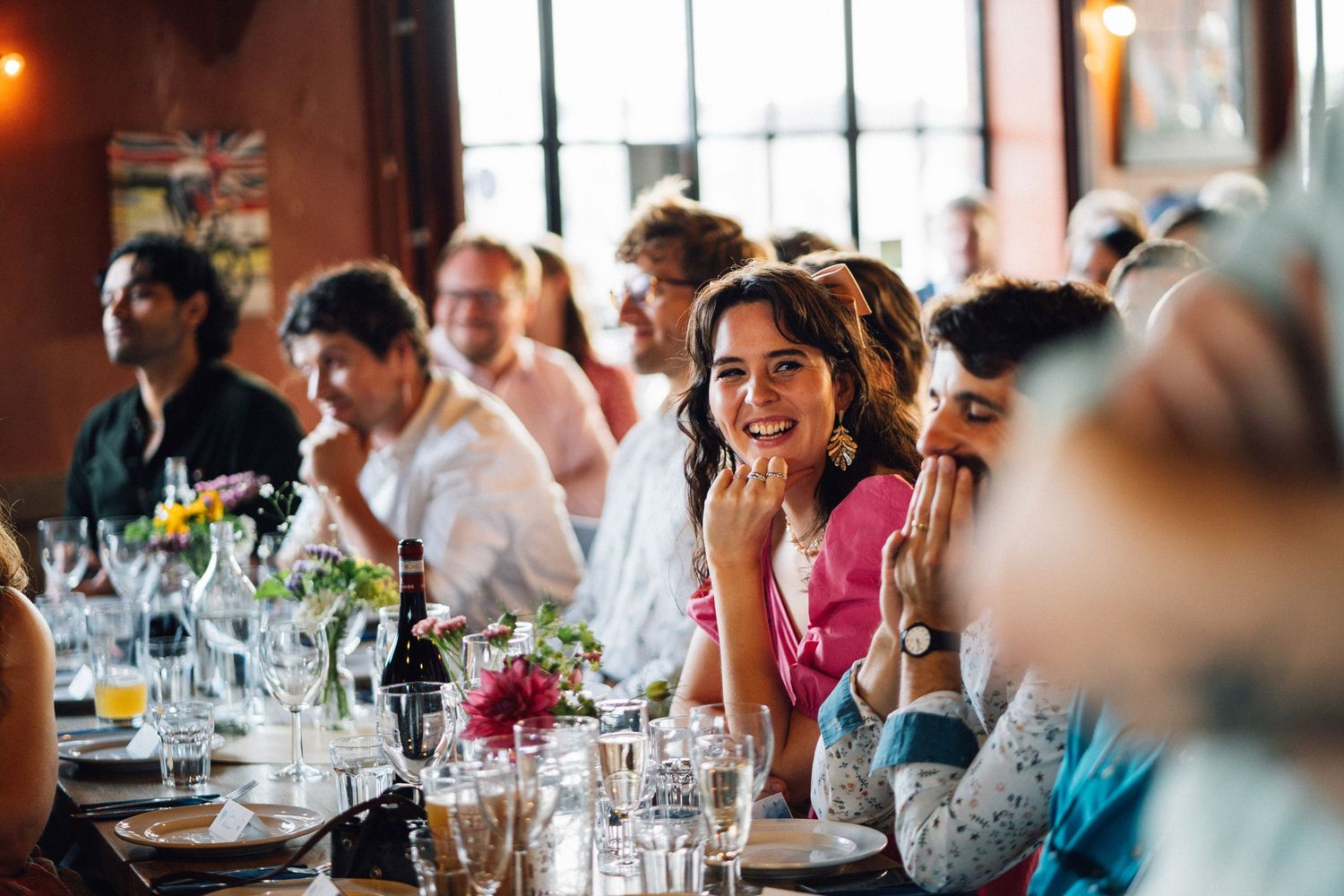 Guests enjoying a celebratory dinner party with wine glasses and table decorations.