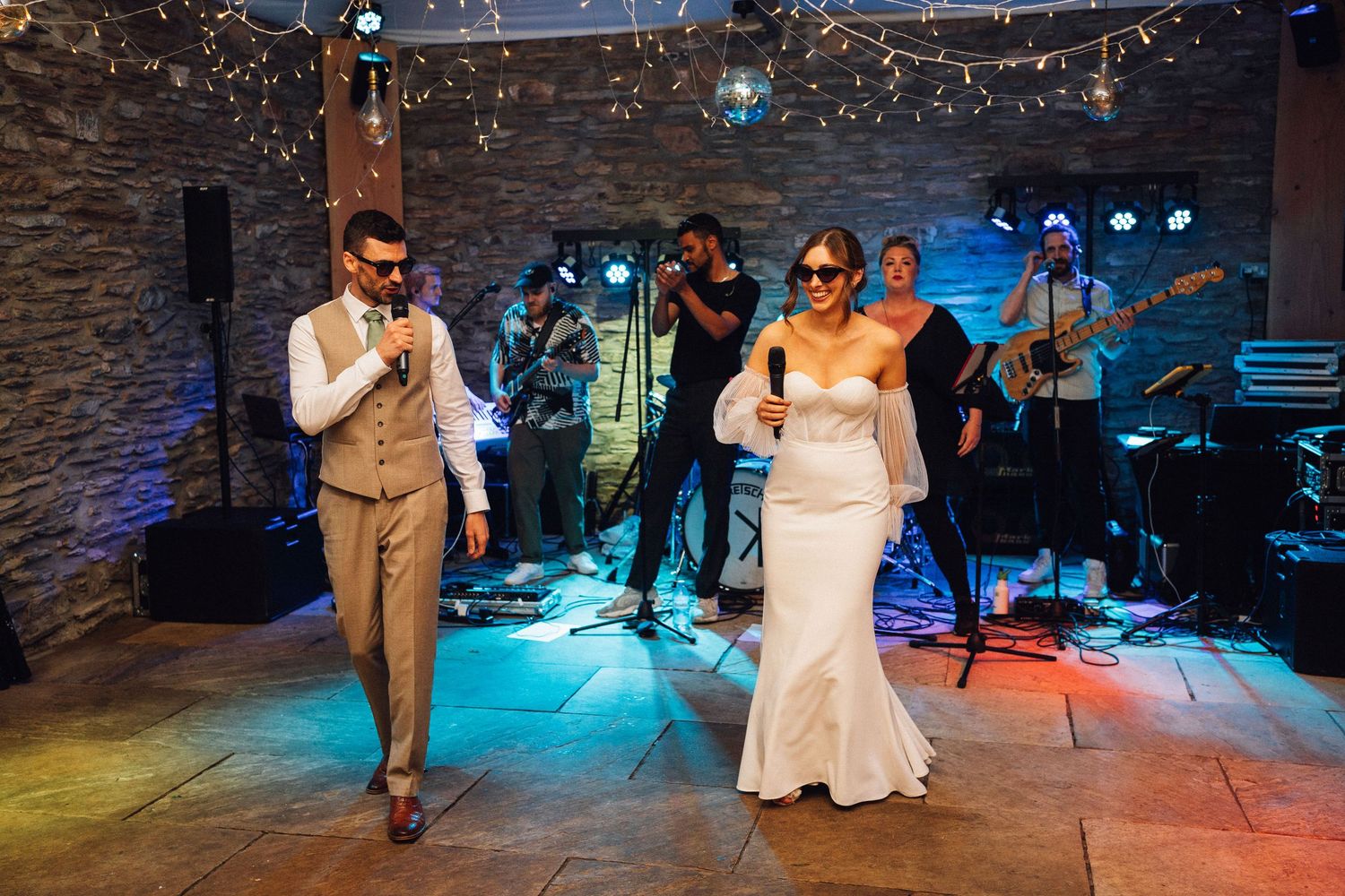 Couple making grand entrance at wedding reception with live band performing.