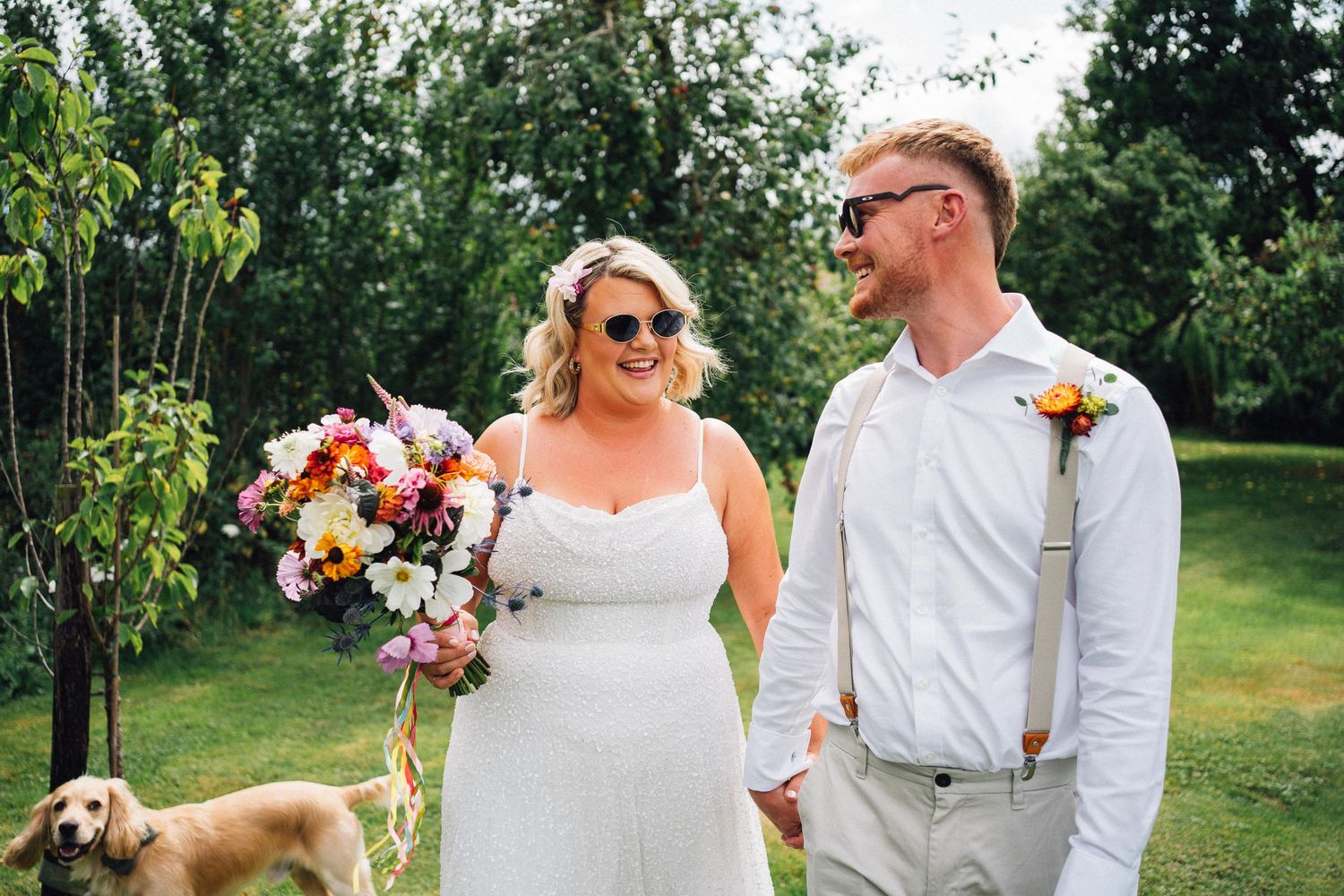 Outdoor garden wedding scene with floral arrangements and natural greenery.