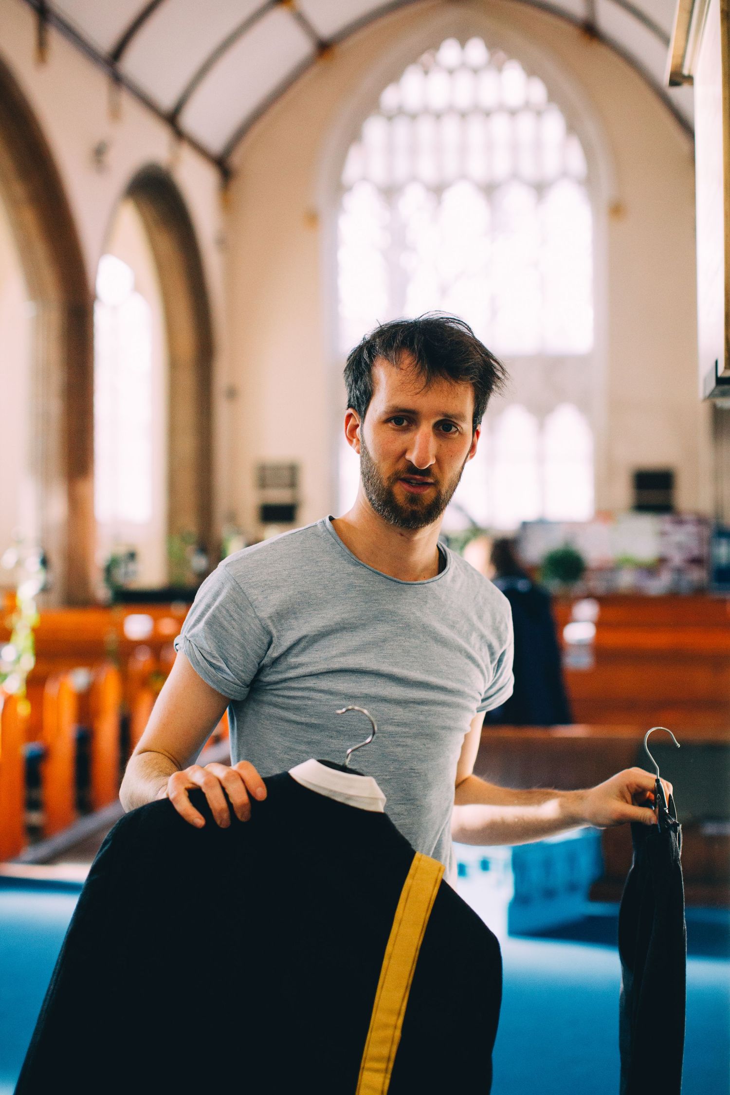 Setting up equipment inside historic church with arched windows.