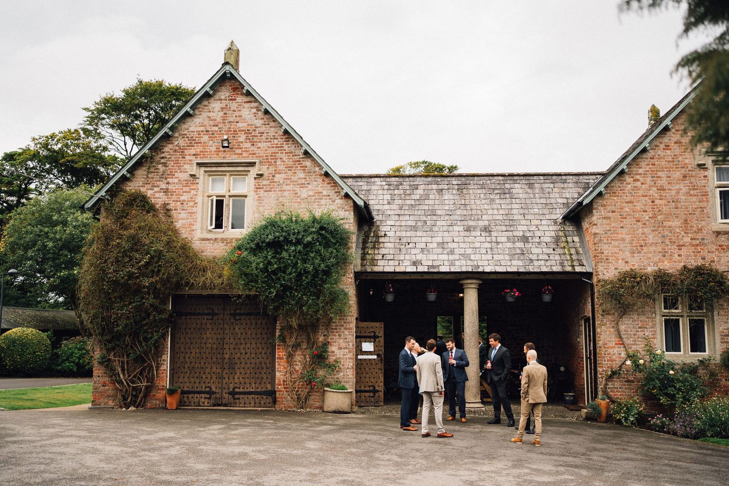 A rustic brick barn venue with multiple exterior views showing stone walls and wooden beams in a countryside setting.