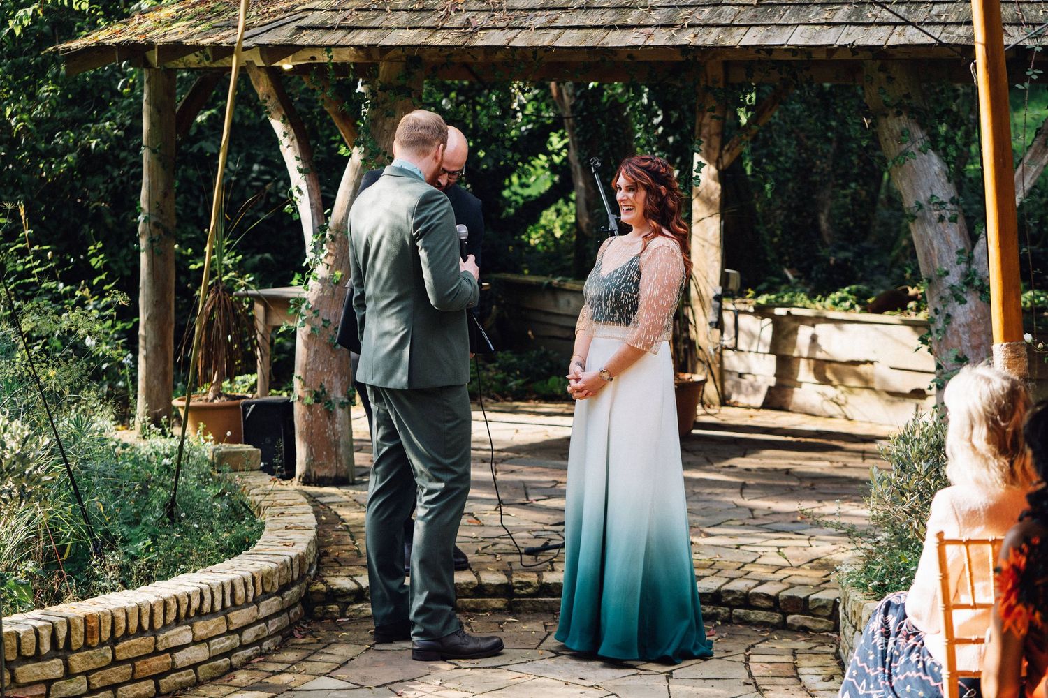 A couple poses with their golden retriever dog in a garden setting during a wedding photoshoot.