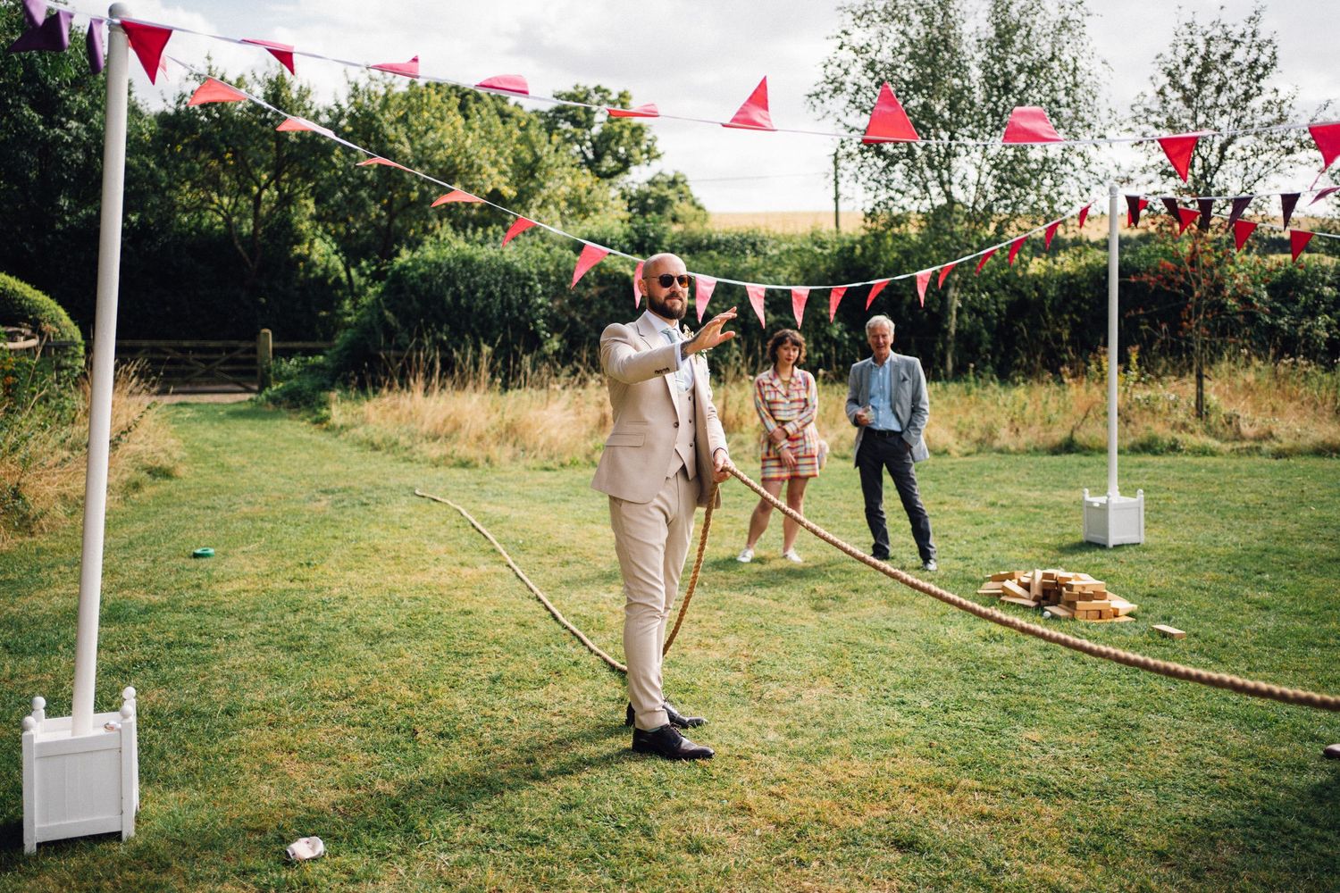 Outdoor garden party setup with red and white bunting decorations on a sunny day.