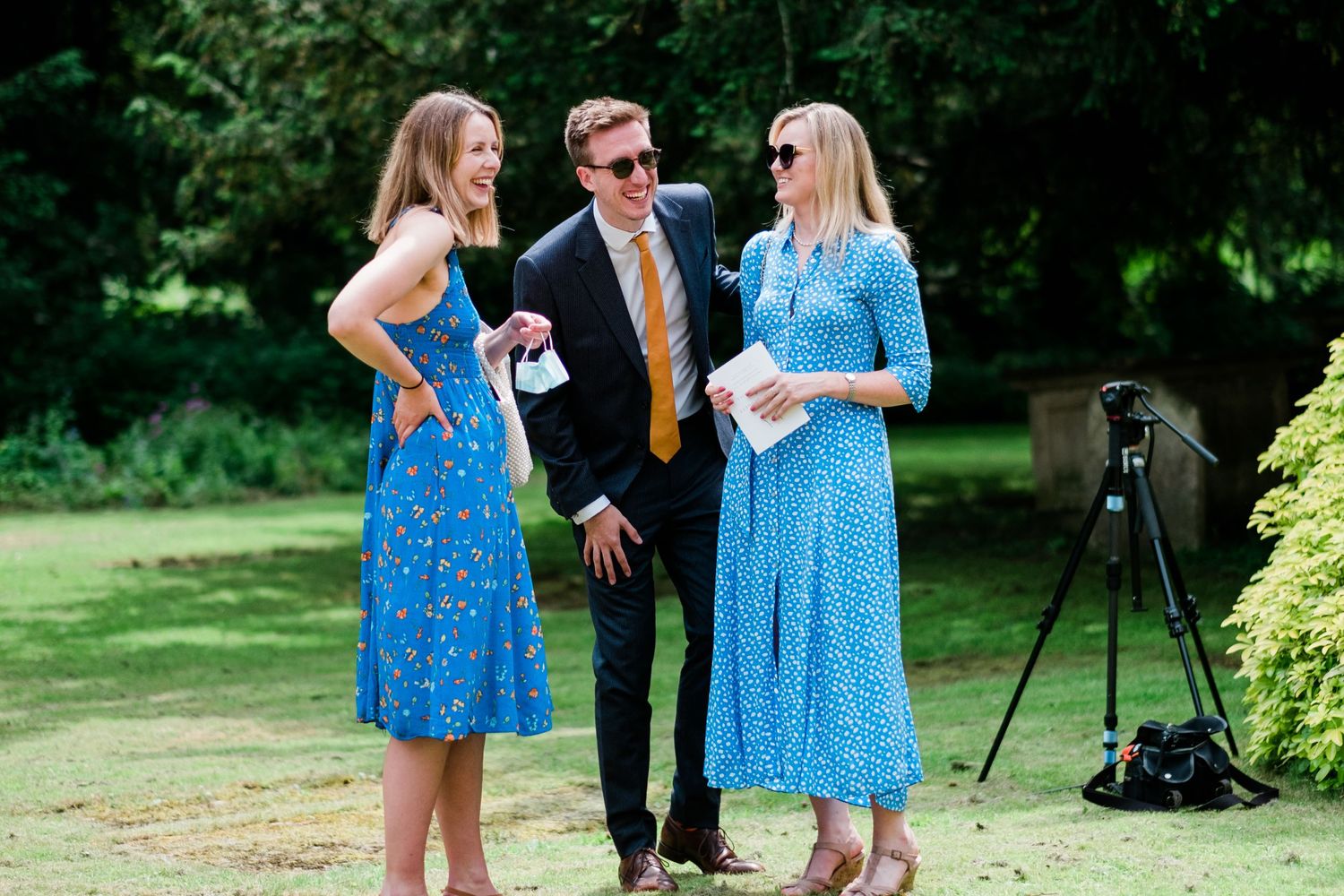 Garden wedding reception with guests in bright summer dresses.