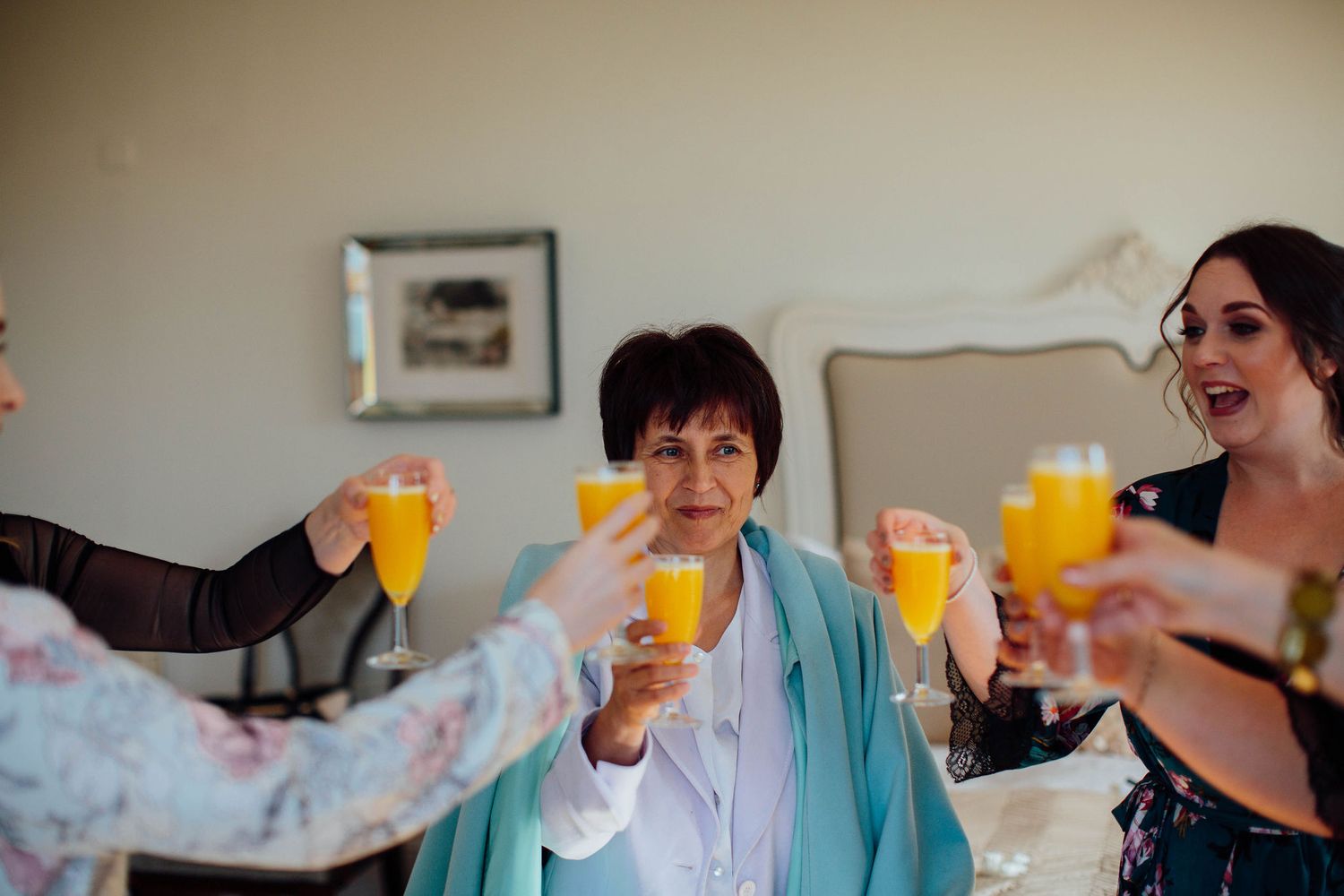 Wedding party toasting with champagne glasses in matching robes.