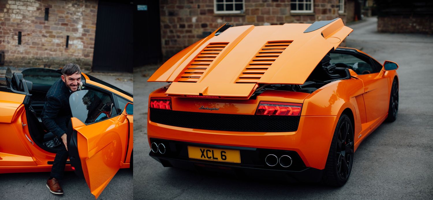 An orange Lamborghini with its door open parked near a brick building.