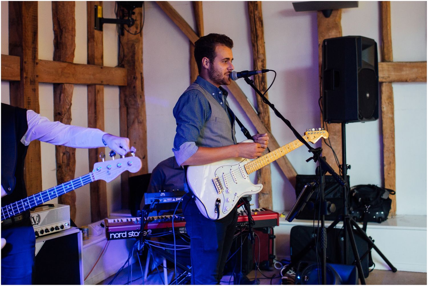 Musicians perform with guitars and instruments at a wedding reception.