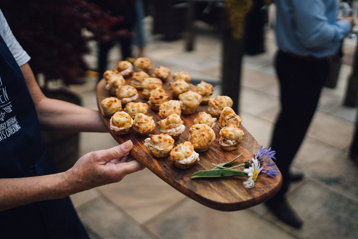 Appetizers being served on wooden boards at an elegant event.