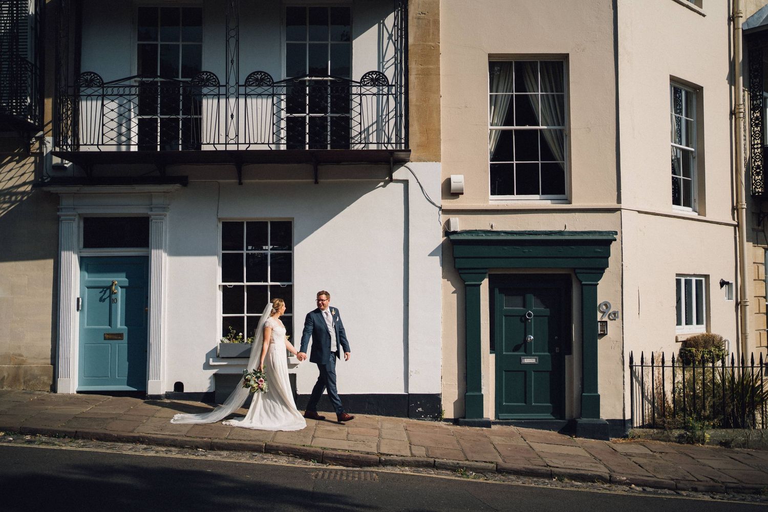 Couple standing in front of a historic building entrance with stone columns and white trim.