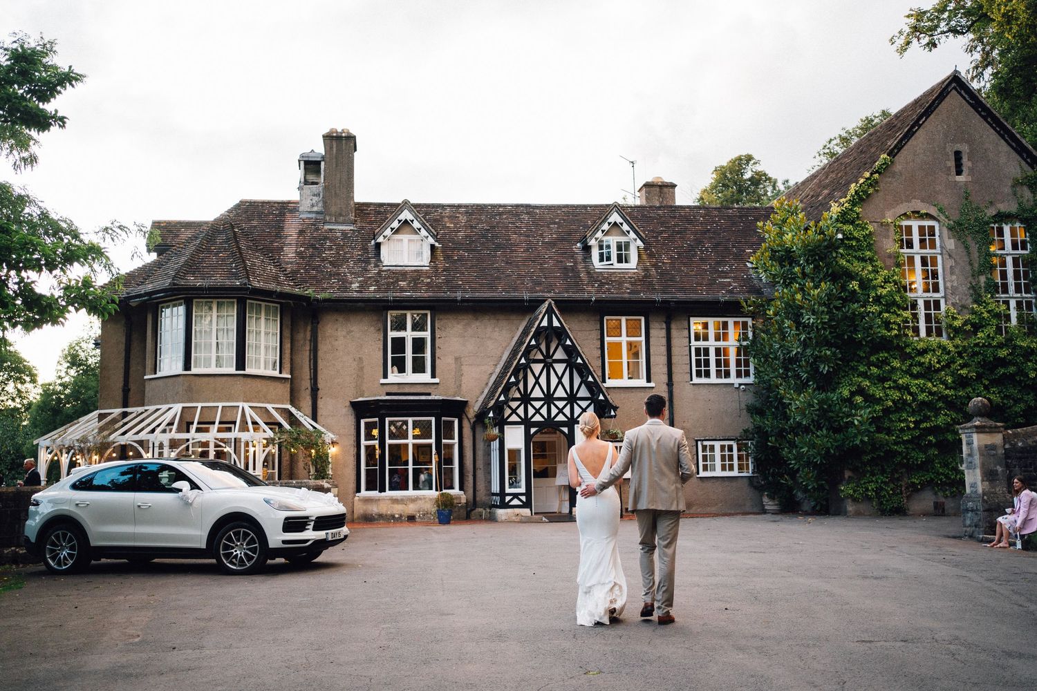 Panoramic view of a traditional English country house wedding venue with parked cars.
