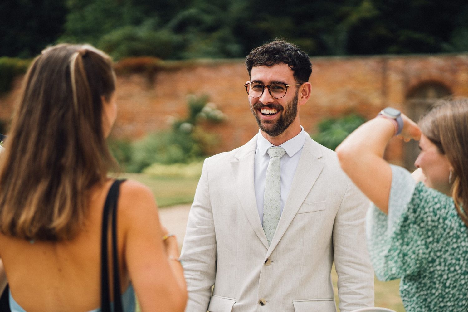 Wedding attendees gather for an outdoor celebration in formal attire.