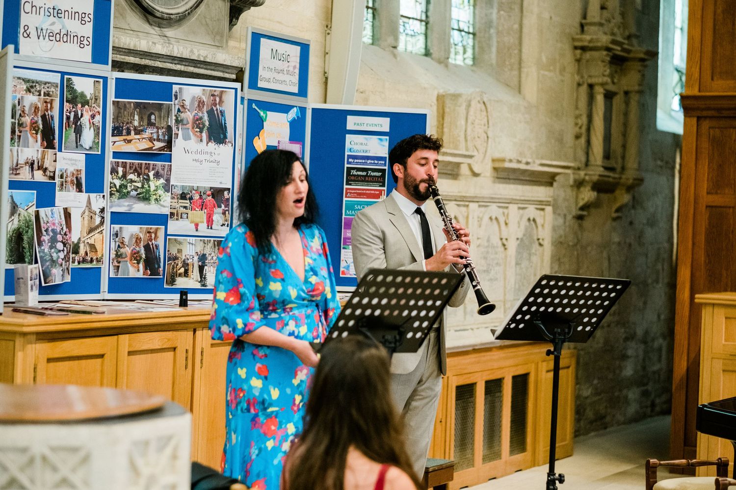 Musicians performing during church wedding with display boards in background.