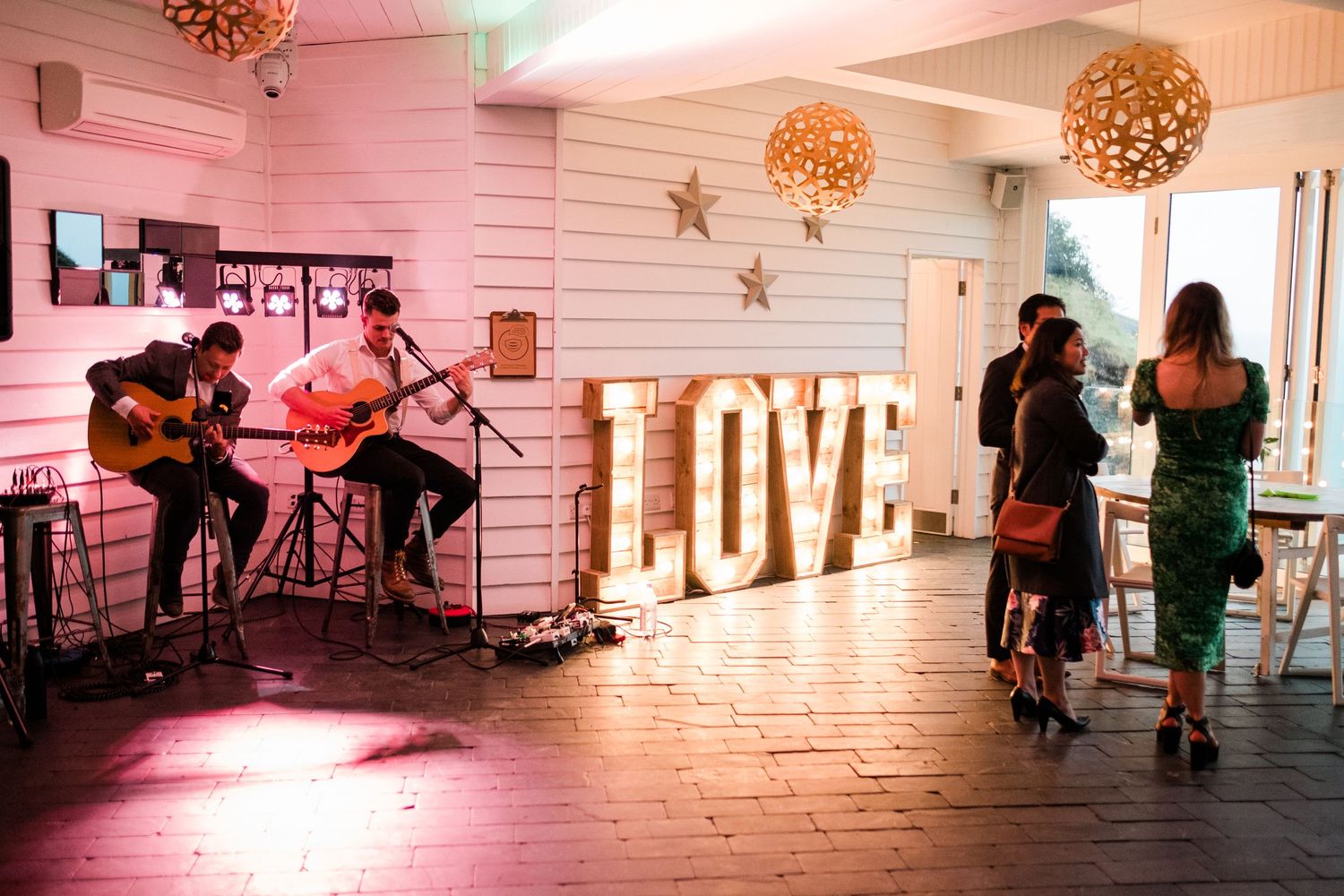 Wedding venue with illuminated LOVE sign and ambient pink lighting.