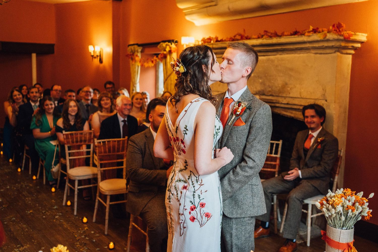 A couple shares an intimate dance moment during their wedding reception in a warmly lit ballroom.