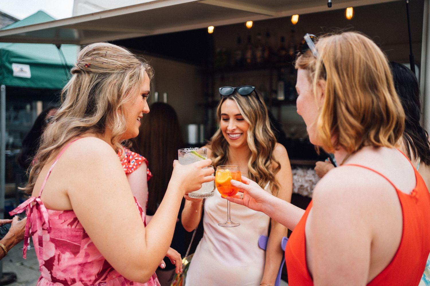 Wedding guests enjoying a casual outdoor reception with string lights overhead.