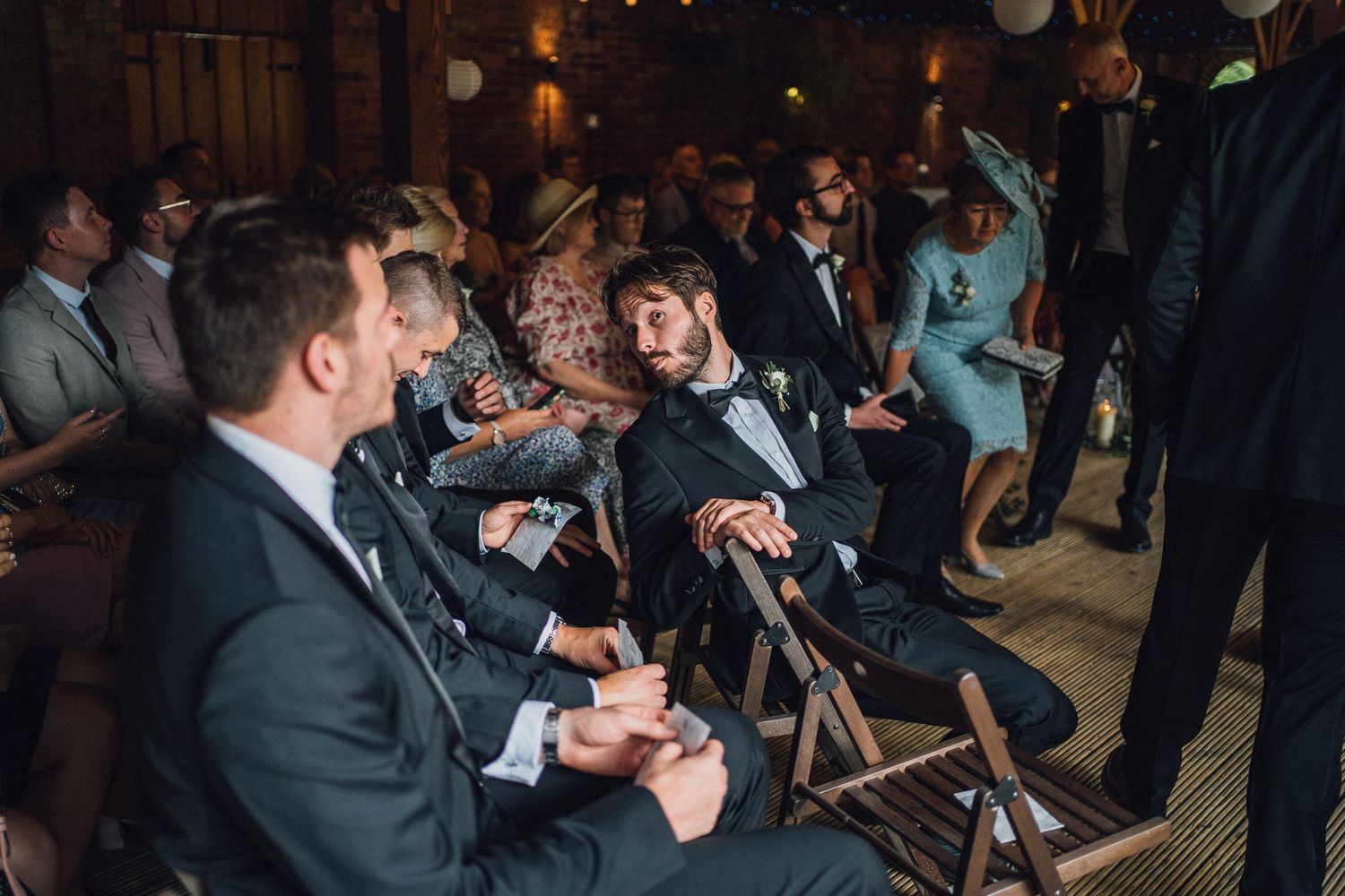 Wedding guests enjoy entertainment in a rustic venue with ambient lighting.