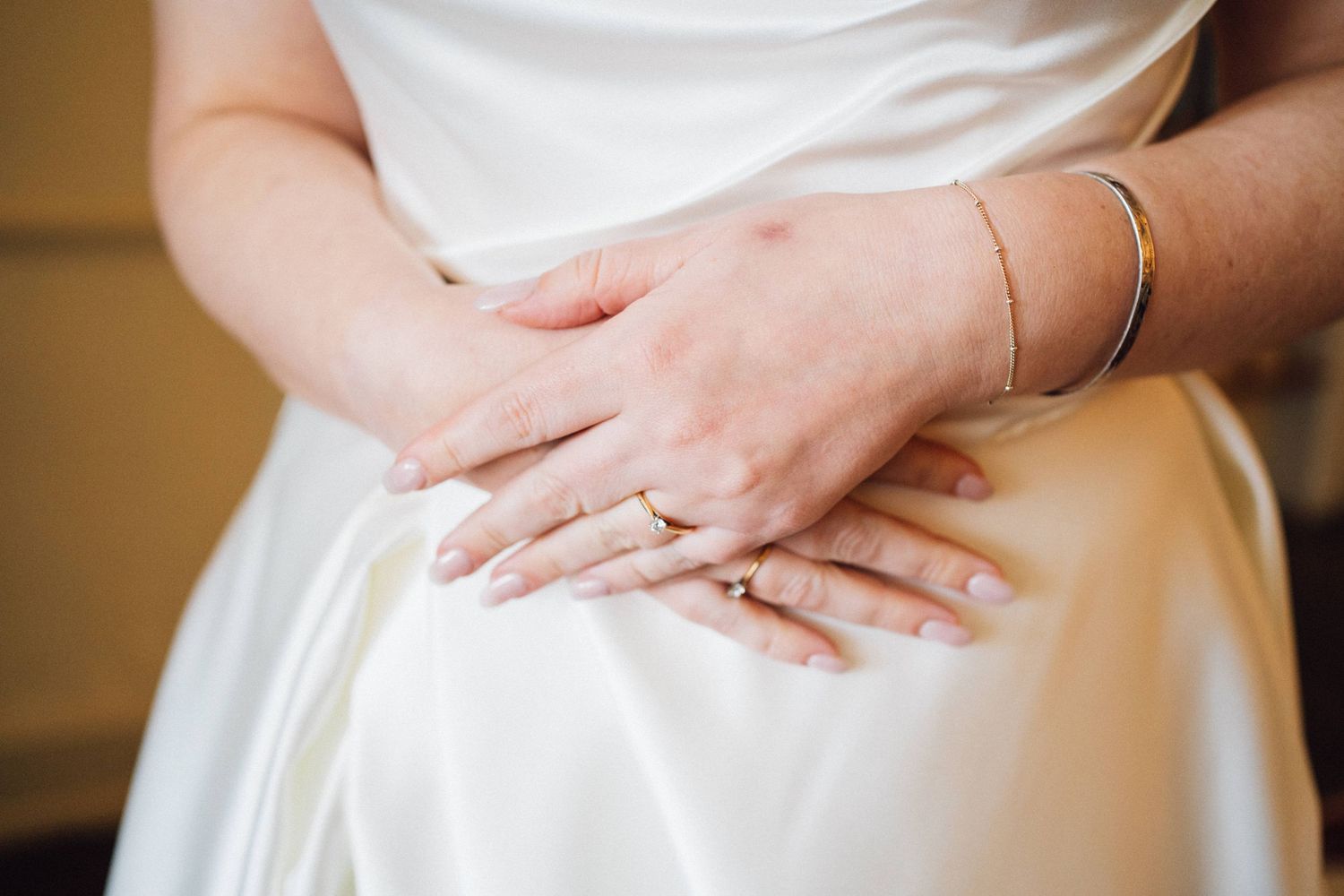 Close-up detail shots of a white wedding dress being adjusted and smoothed.
