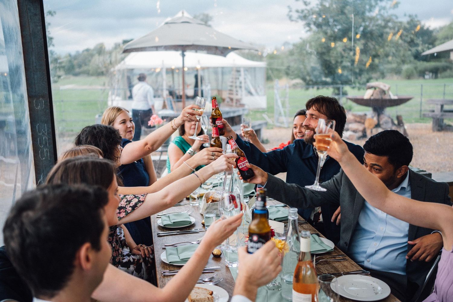 A group of people raising glasses and toasting together during a celebration at a restaurant.