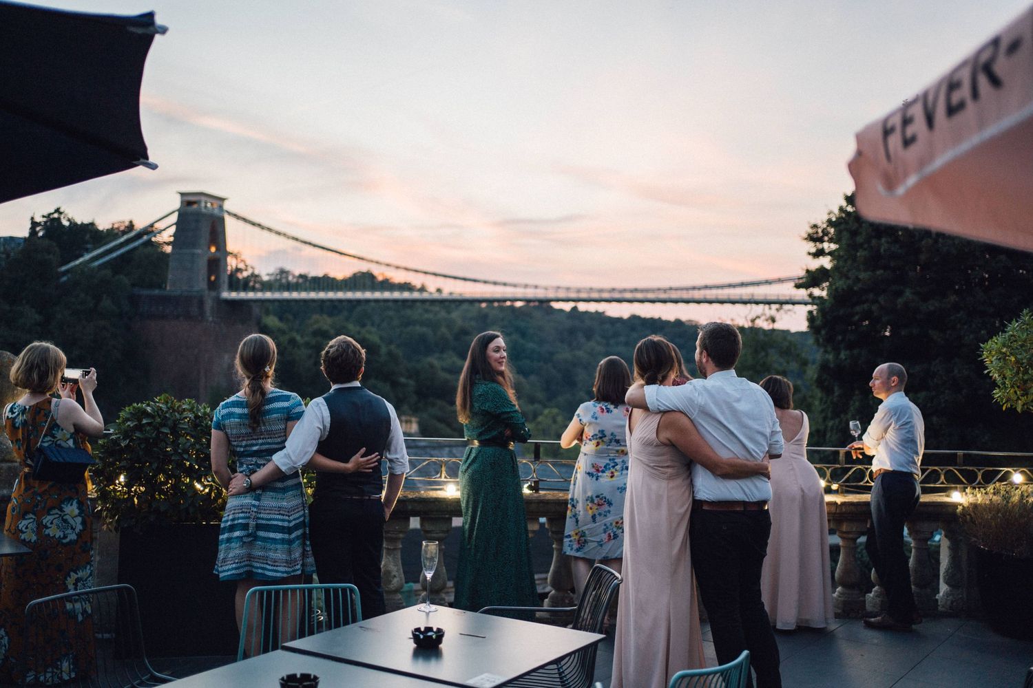 Guests enjoying a rooftop party at dusk with Clifton Suspension Bridge in the background, Bristol.