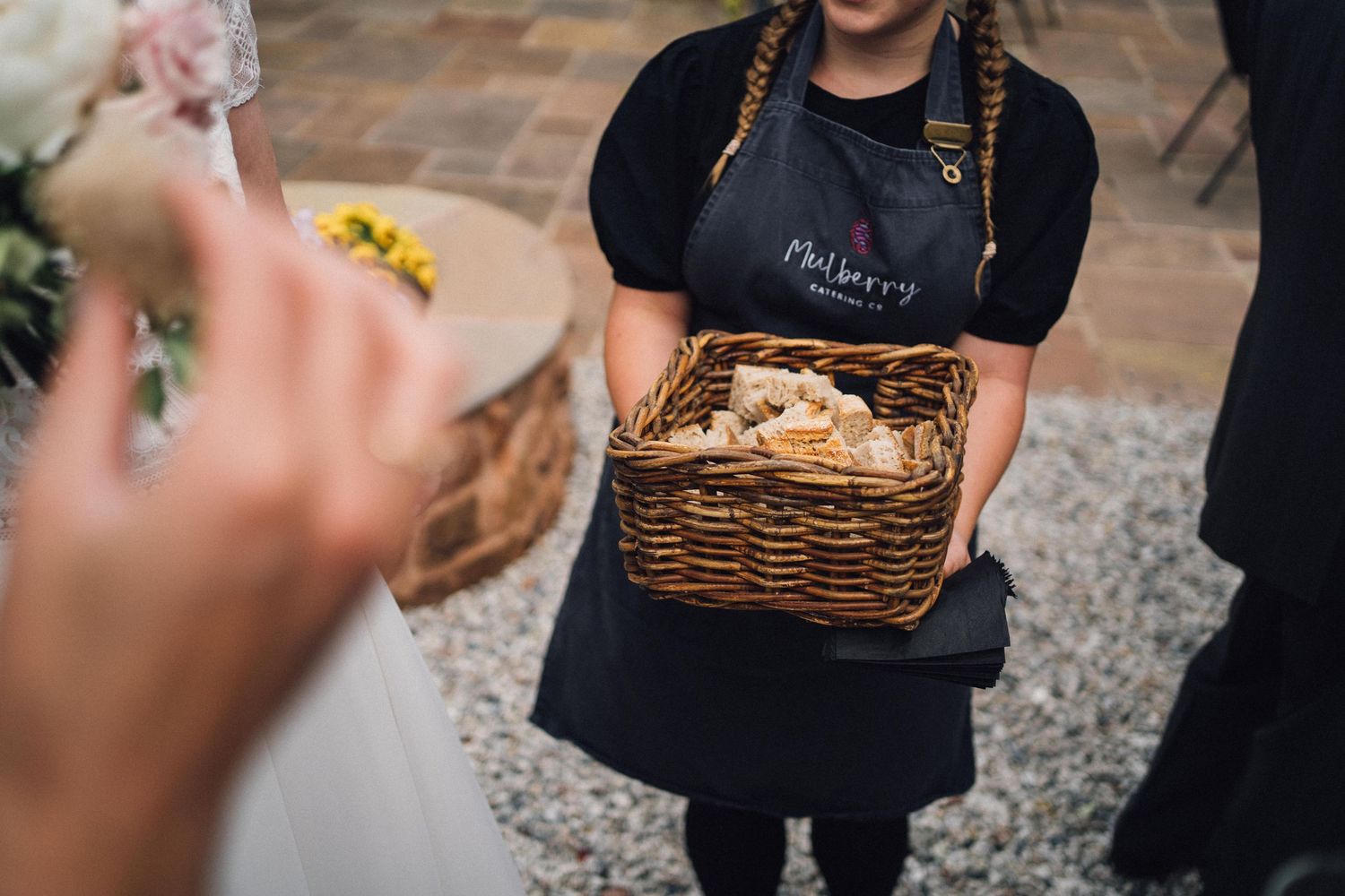 Catering staff presenting hors d'oeuvres on wooden serving boards.