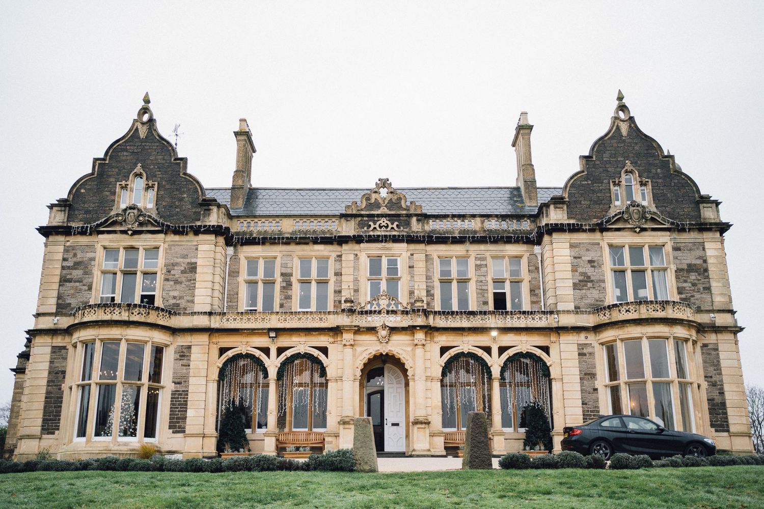 Historic stone mansion exterior with Gothic architecture and ornate windows.