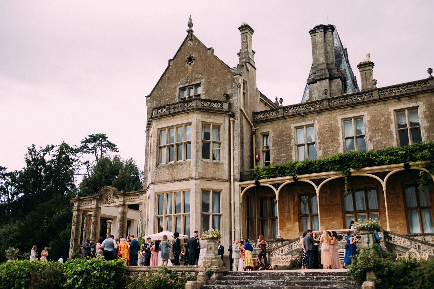 Wide angle view of elegant stone mansion wedding venue with classic architecture.