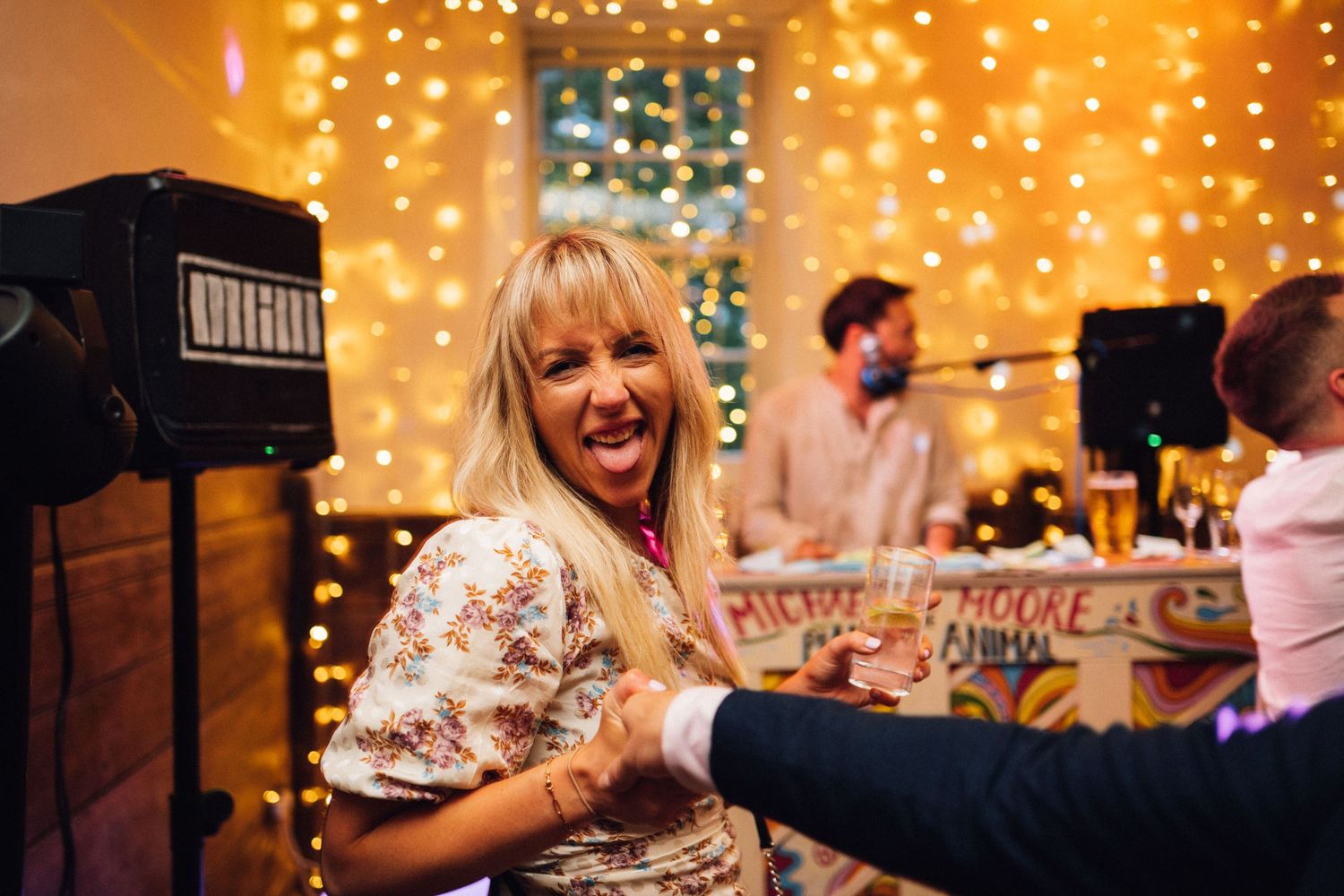 People enjoying a festive party with string lights and decorations creating a warm, glowing atmosphere.