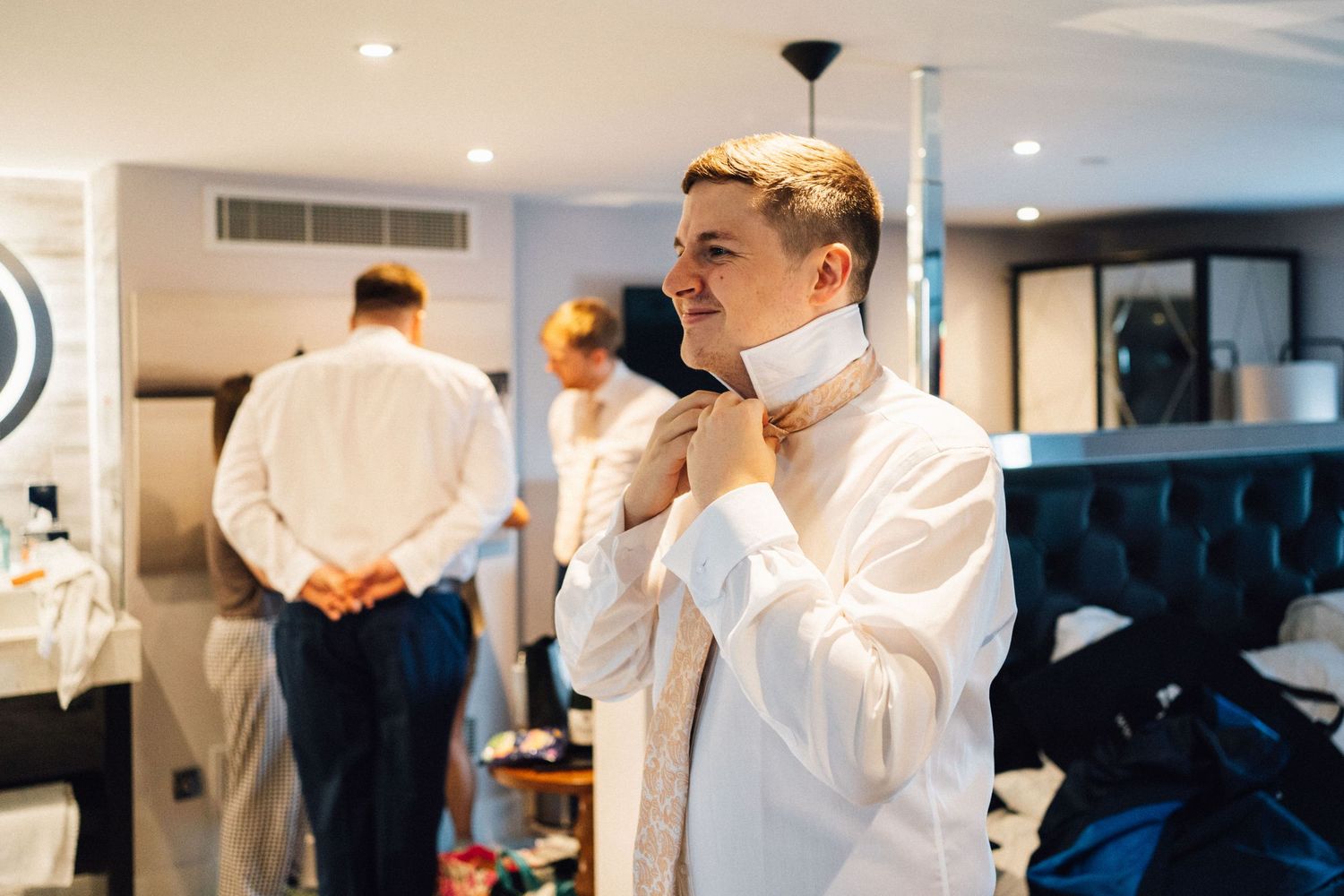 Chefs in white coats gather in a bright modern kitchen for a professional tasting and discussion session.