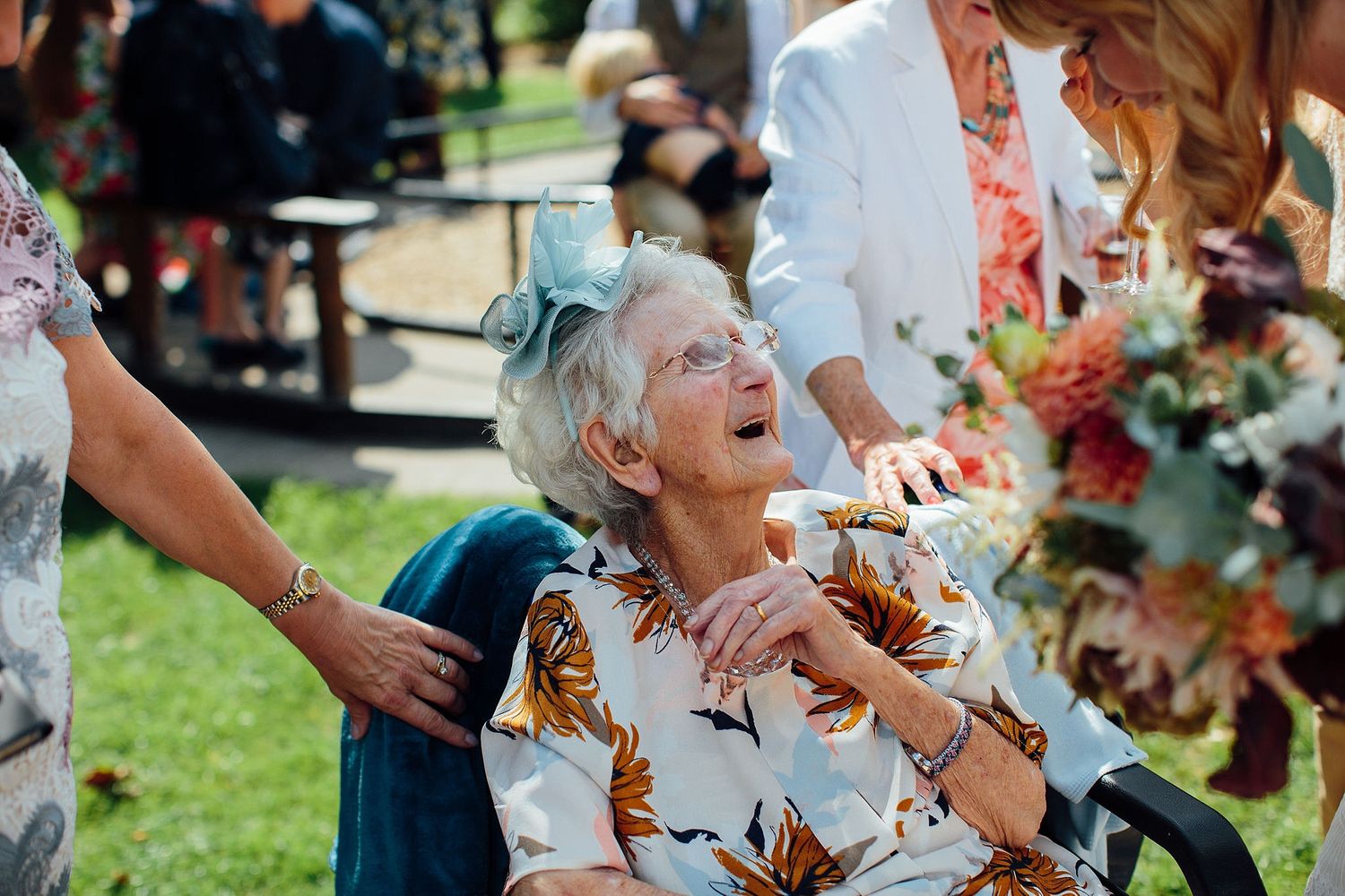 Guests celebrating at an outdoor wedding reception with floral decorations.