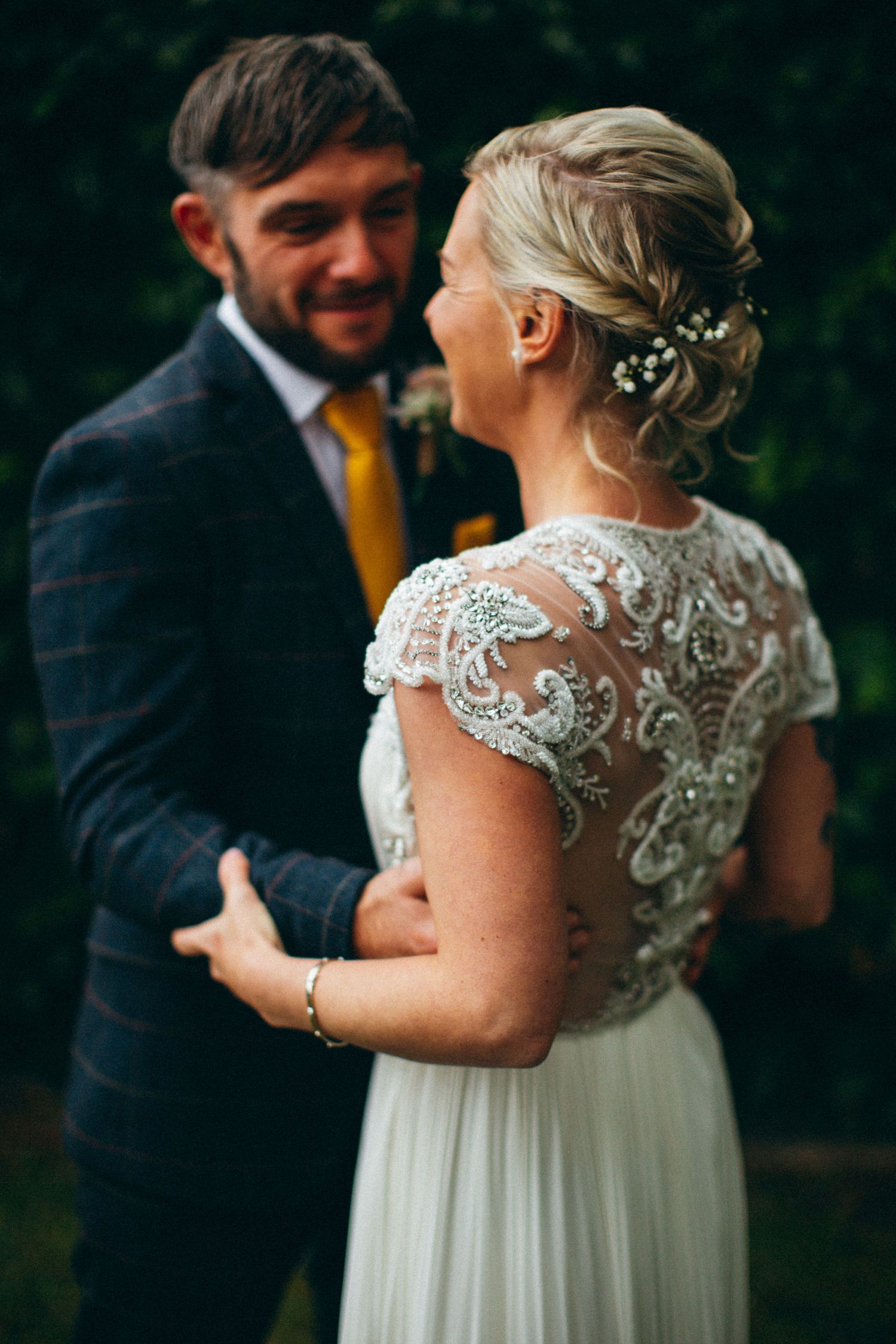 Intimate wedding portraits showing joyful embraces against a dark background.