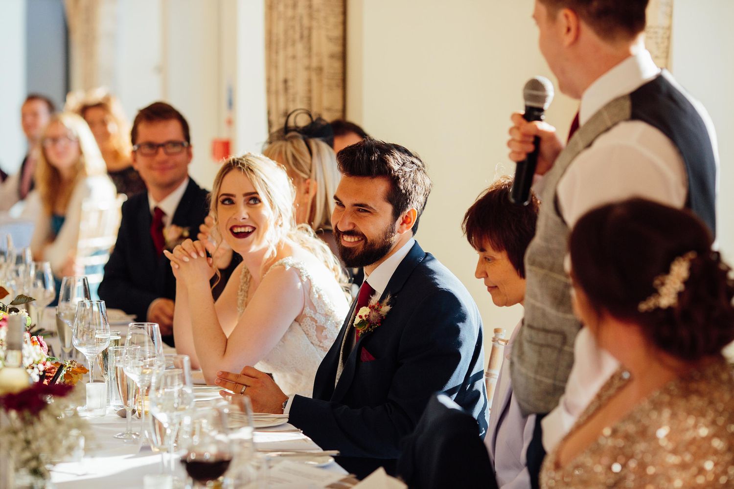 Wedding guests enjoying a formal dining reception in an elegant indoor venue.