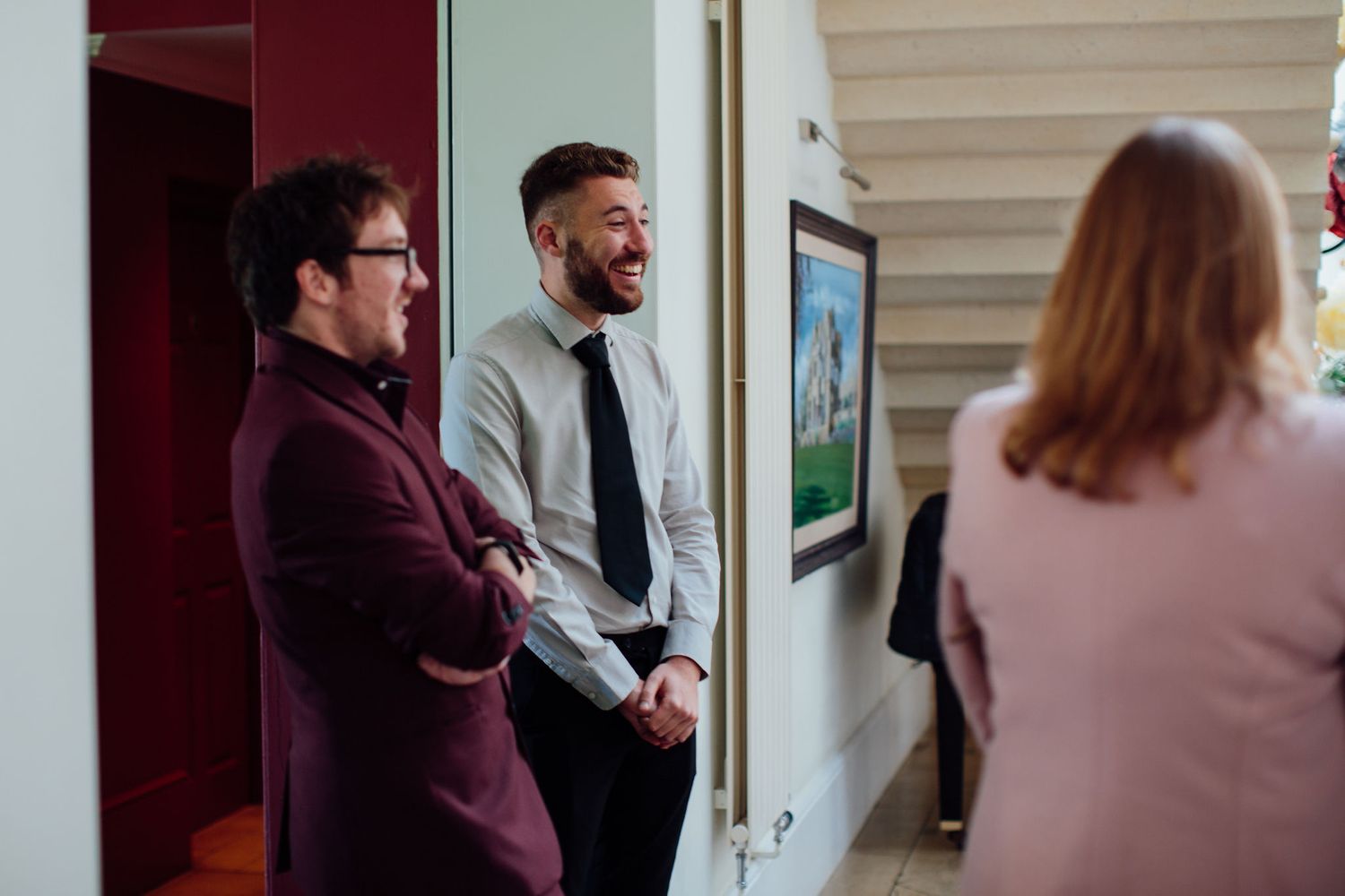 Wedding guests mingling in an indoor reception space with warm lighting.