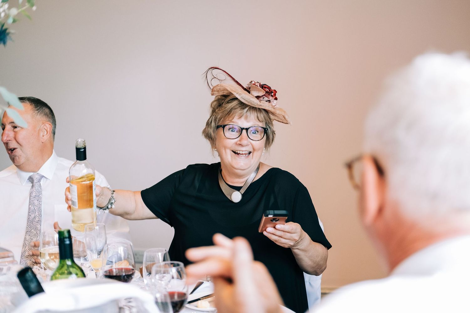 Candid moments of wedding guests laughing and socializing during the reception.