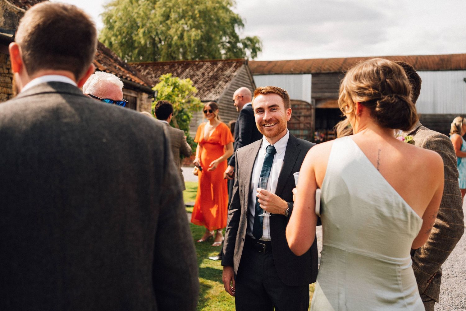 Wedding guests mingle and chat during an outdoor garden reception.
